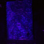 A picture of my sketchbook glowing under a blacklight